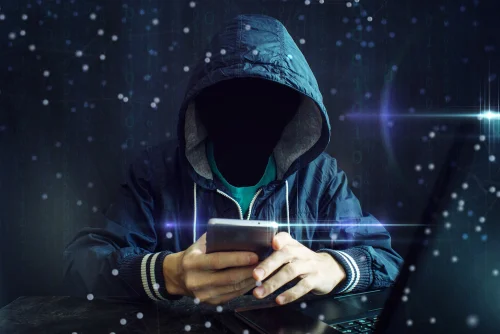 person in a sweatshirt with an outer space background looking at his phone ominously