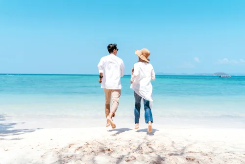 man and woman running on beach